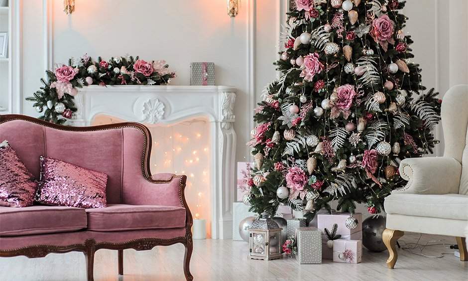 Decorate a christmas tree with artificial pink roses, bright ball and pine cone ornaments