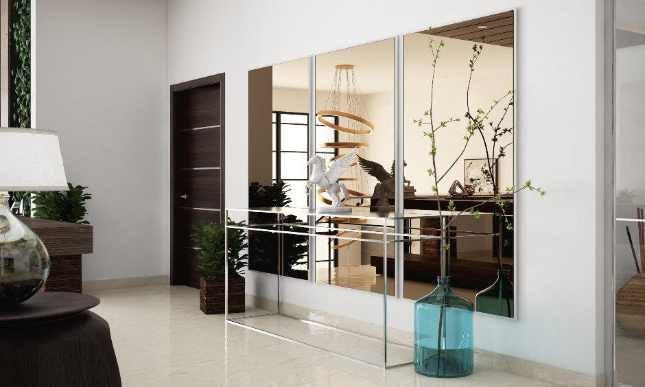 Simple drawing room designs in India showing drawing room wall design and decoration using mirrors and side tables to bring contemporary look.