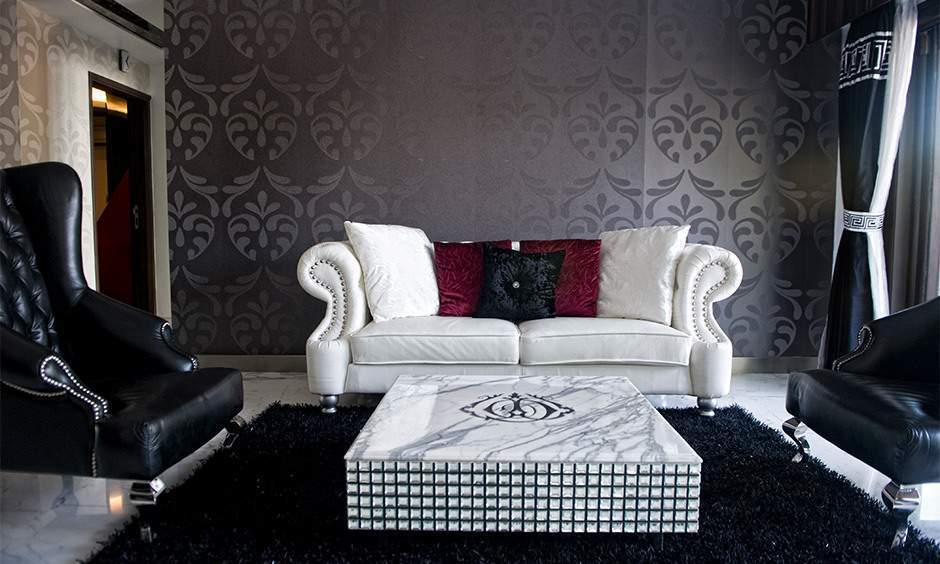 A lavish drawing room interior with an elegant coffee table, books, flowers, and stylish decor.